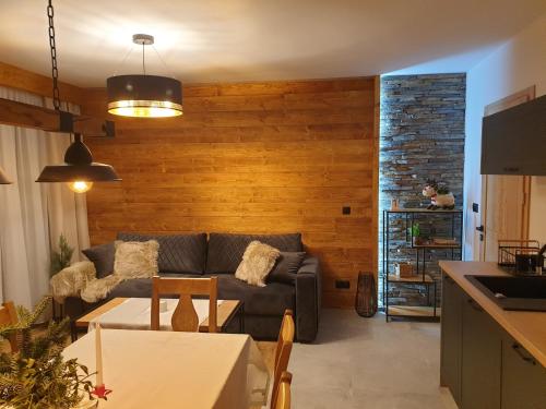 什恰夫尼察Korona Pienin Domki & Apartamenty的客厅配有沙发和桌子