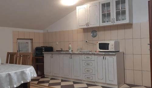 巴尼亚卢卡LUX APARTMENT的厨房配有白色橱柜和微波炉