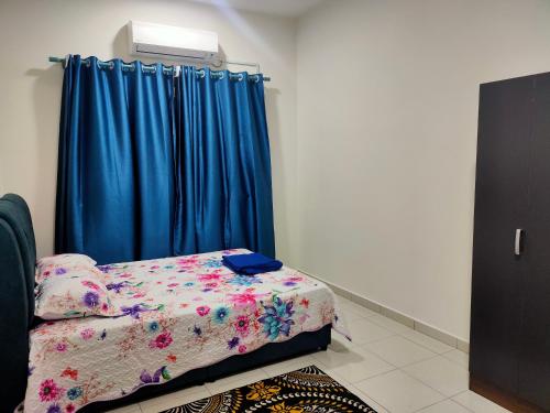 安顺Homestay Fayyadh Teluk Intan 3Room2Bath的一间卧室配有床和蓝色窗帘