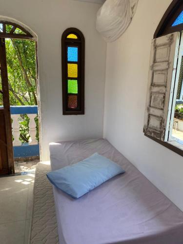 卡马萨里Cantinho dos Machados的小房间设有床和窗户