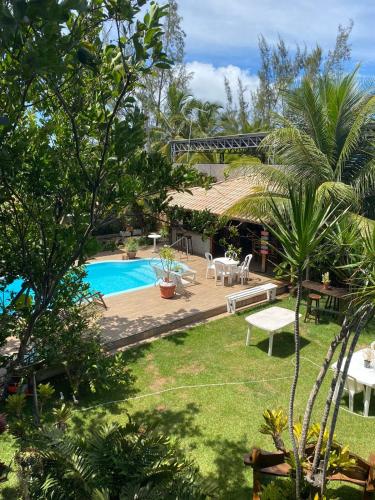 卡马萨里Cantinho dos Machados的后院设有游泳池、桌子和椅子