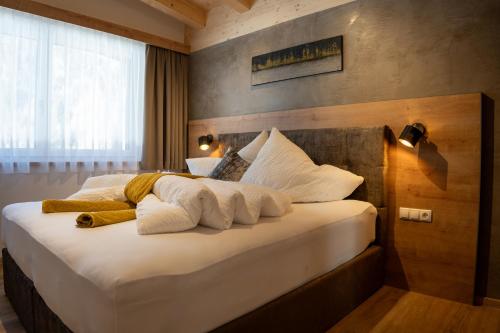 乌姆豪森Apart Dorhoam的一间卧室配有带白色床单和枕头的床。