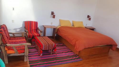Comunidad YumaniCAMPO SANTO的一间卧室配有一张床和两把椅子