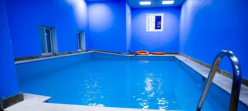 吉达HAWADA PIONEER的蓝色的房间,设有一座带蓝色墙壁的游泳池