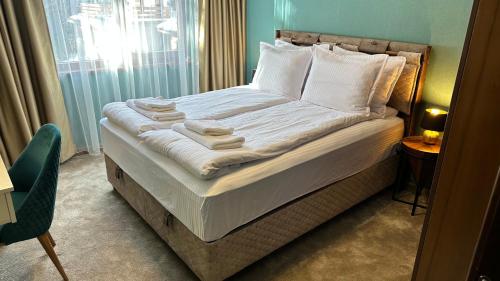 潘波洛沃ELEA Apartment Mountain Lodge Pamporovo的一间卧室配有带白色床单和枕头的床。