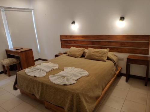 费德拉西翁Urban Hotel的一间卧室配有一张床,上面有两条毛巾