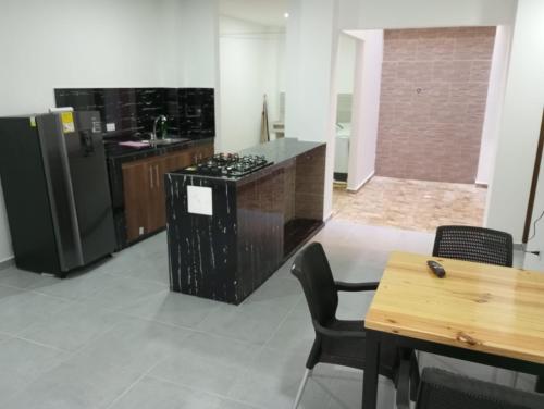 科韦尼亚斯Apartamento Villa Mary-Coveñas的厨房配有炉灶、冰箱和桌子