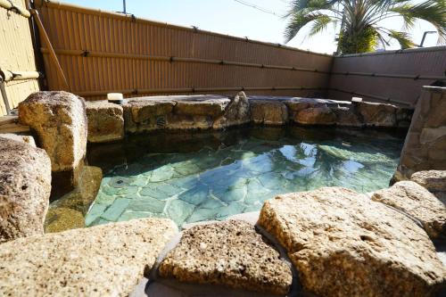 白滨白浜・温泉リゾート海岳的后院中一座带岩石的大型游泳池