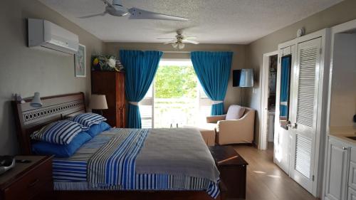 尼格瑞尔Point Village的一间卧室配有床和蓝色窗帘的窗户