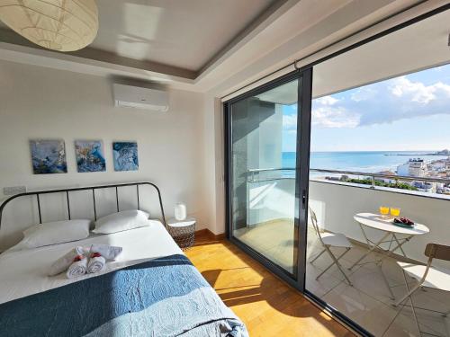 拉纳卡Dios Ponte Finikoudes Beachfront Duplex Penthouse的一间卧室配有一张床,享有海景