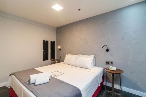 巴西利亚Apartamento em hotel 5 Estrelas Brasília - GMB0414的卧室配有一张带两张桌子的大型白色床