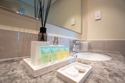 迪拜Veluxa - Luxe 2Bed in Downtown!的一间带水槽和花瓶的台面浴室