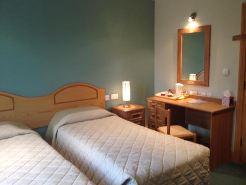 Achill SoundAnvil House的酒店客房设有两张床、一张桌子和一面镜子