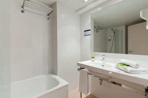 圣克鲁斯Santa Limbania Boutique Hotel的一间带水槽、浴缸和镜子的浴室