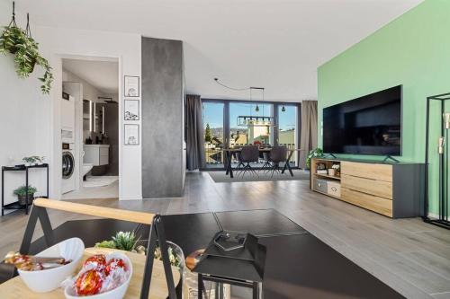 苏黎世Outstanding Boutique-Designer Apartment - private Rooftop Terrace - fully equipped的厨房以及带桌子和电视的客厅。