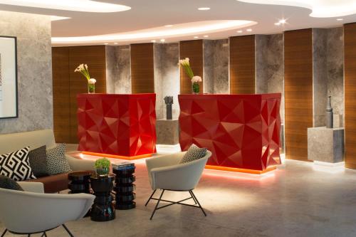 巴黎Renaissance Paris Republique Hotel & Spa的大堂配有沙发、椅子和红色柱子