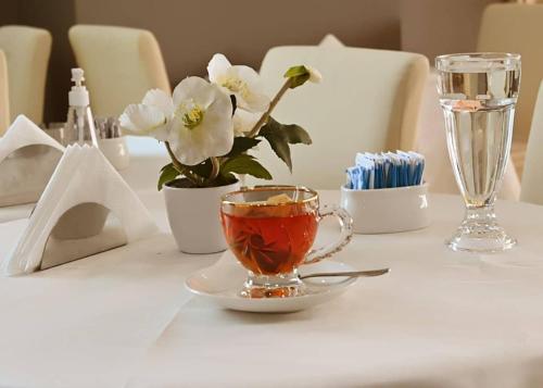 阿吉曼Bareen Hotel的坐在桌子上,一边喝茶一边欣赏鲜花
