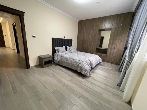 亚的斯亚贝巴The Hub的一间卧室配有一张床,铺有木地板