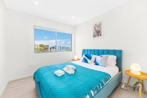 悉尼Entire Home in Lidcombe的一间卧室配有蓝色的床和毛巾