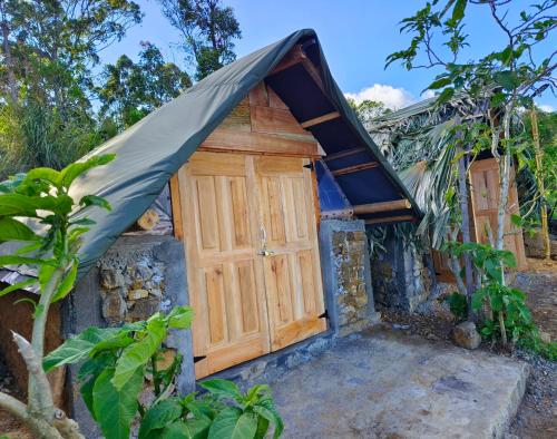 哈普特莱Eco Lodge Haputale-Camping Sri lanka的一座带倾斜屋顶和车库的房子