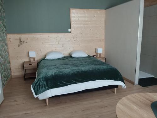 Alternative hôtel的一间卧室配有一张带绿色棉被的床