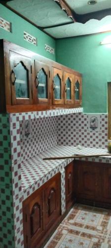 亭可马里Dino Enjoy Property的浴室设有水槽和绿色墙壁上的镜子