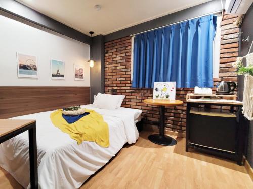 议政府市Residence YeoYu Uijeongbu Station的一间卧室设有一张床和砖墙
