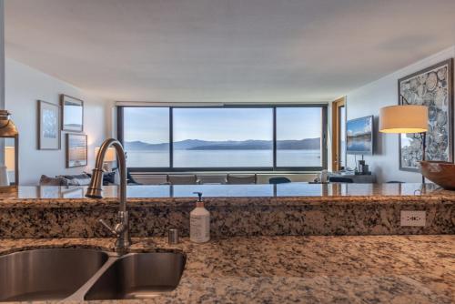 国王海滩Luxurious Lakefront Condo with Lake Views in Brockway Springs Resort Close to Slopes的一个带水槽和大窗户的厨房