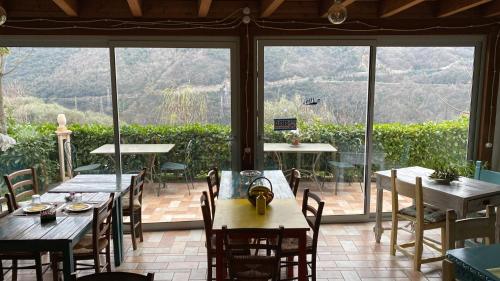 菲纳莱利古雷Agriturismo La Contessa的餐厅设有桌椅和大窗户。