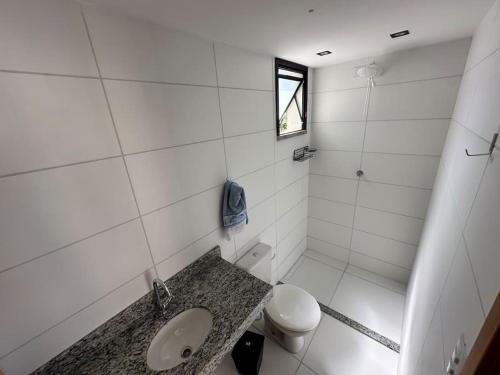 伊列乌斯Apartamento Para Temporada的白色的浴室设有卫生间和水槽。