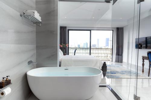 岘港Quang Minh Riverside Hotel Danang的带浴缸的浴室和卧室