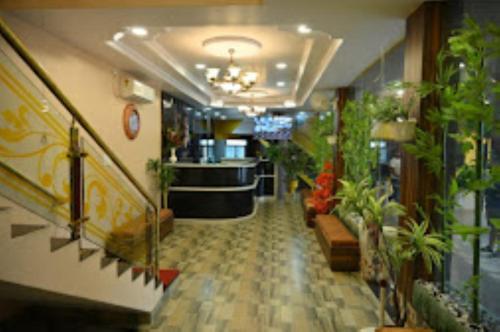 JagdalpurHotel Aaradhya International Jagdalpur的楼内带有盆栽的走廊