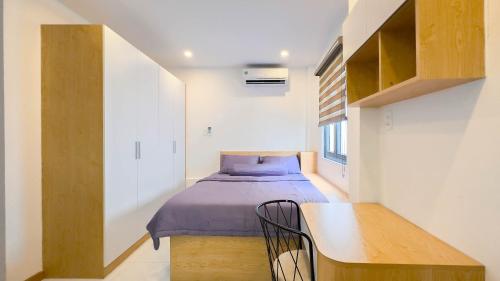 胡志明市Lucy House的一间小卧室,配有一张床和一张桌子