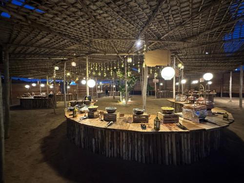 HunaywahAl Khayma Camp "Elite Camping & Dining in Experience"的大型客房,设有大桌子,位于大楼内