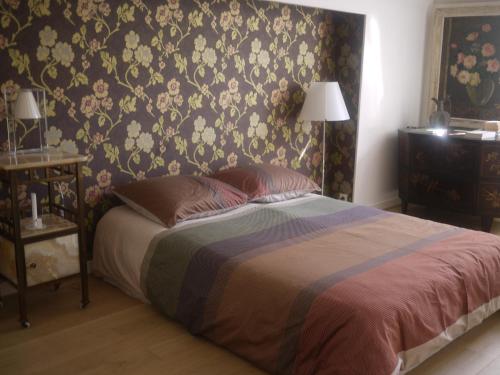 普卢阿Nature, Mer, Golf & Decouvertes...的一间卧室配有一张带花卉壁纸的床