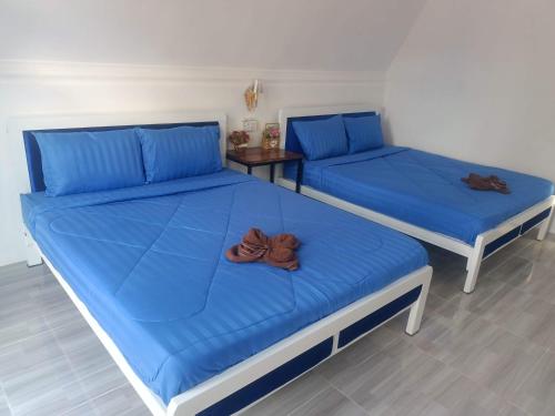 Phumĭ Kâoh RŏngBlue Zone Hostel的客房内的两张床和蓝色床单
