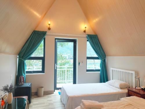 峰牙杨桃简易别墅 的阁楼卧室设有两张床和窗户。