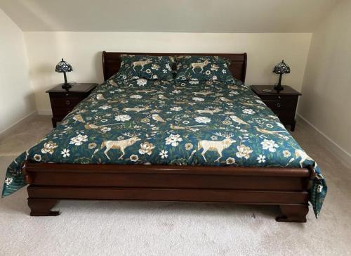 霍利黑德Entire cosy home from home country retreat的一张带花卉棉被和2晚床头柜的床