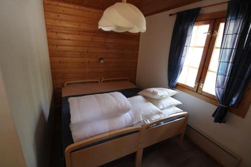 KoroVilla Nurminiemi的小房间设有一张带白色床单和枕头的床