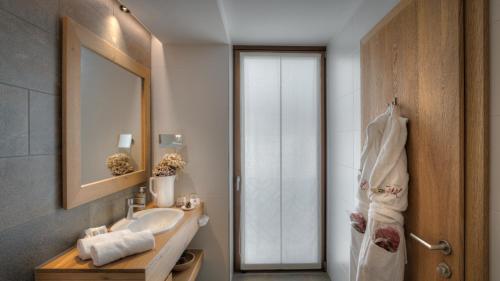 圣坎迪朵Il Tyrol的一间带水槽和镜子的浴室