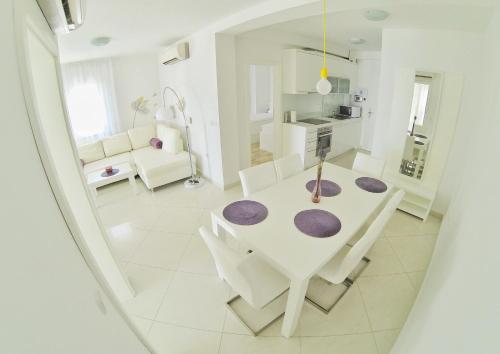 诺瓦利娅Apartments Barbati的白色的用餐室配有白色的桌椅