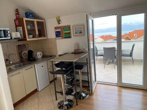 奈维斯Casa Estancia Studio Apartment的一个带桌椅的厨房和一个阳台