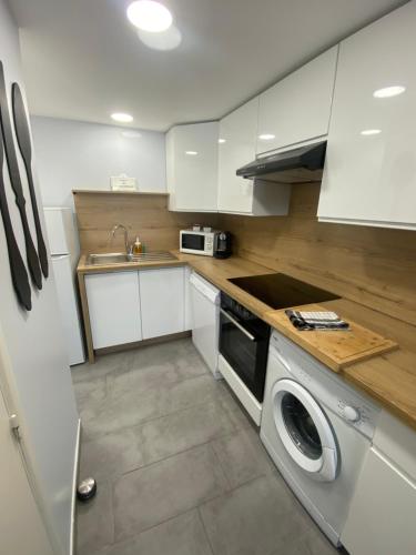 圣艾格夫Appartement Sol y Mar的厨房配有白色橱柜和洗衣机。