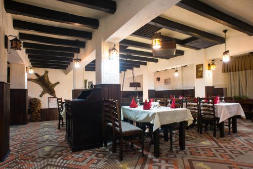 锡纳亚布切吉酒店的餐厅配有桌椅和红色餐巾