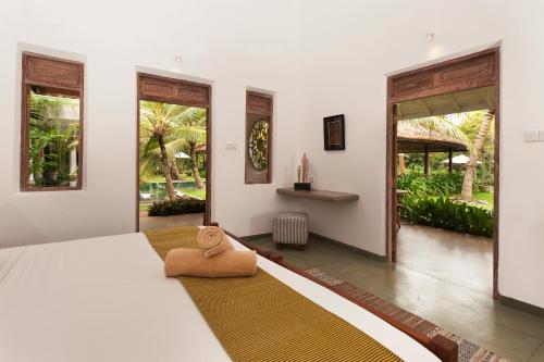 阿杭格默Nirbana Retreat的卧室设有白色大床和窗户。