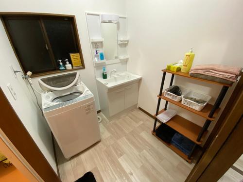 大岛一棟貸しの宿 OKAYADO的一间带水槽和洗衣机的小浴室