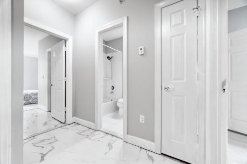 College PointWaterfront Gem Duplex 3 Bedroom 2Floor in Whitestone Bronx Free parking的白色的浴室拥有白色的墙壁和白色的大理石地板。
