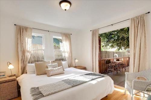 圣巴巴拉Hammonds Beach Haven的一间带一张白色大床的卧室和一个阳台
