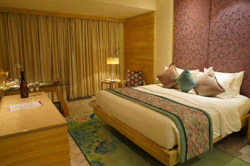 斋浦尔Hotel Royal Orchid Jaipur, Tonk Road的配有一张床和一张书桌的酒店客房