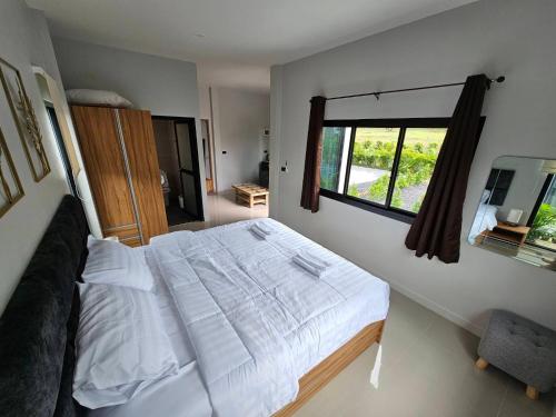 普吉镇The Hill resort Thalang的一间卧室设有一张大床和一个窗户。